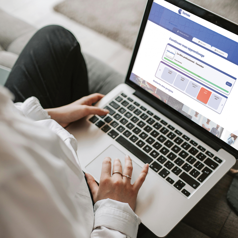 Apprenant utilisant la plateforme LMS Formao sur ordinateur portable pour suivre sa progression en formation professionnelle, illustrant l'expertise du groupe i-maginer en e-learning, edtech et accompagnement des parcours en alternance.